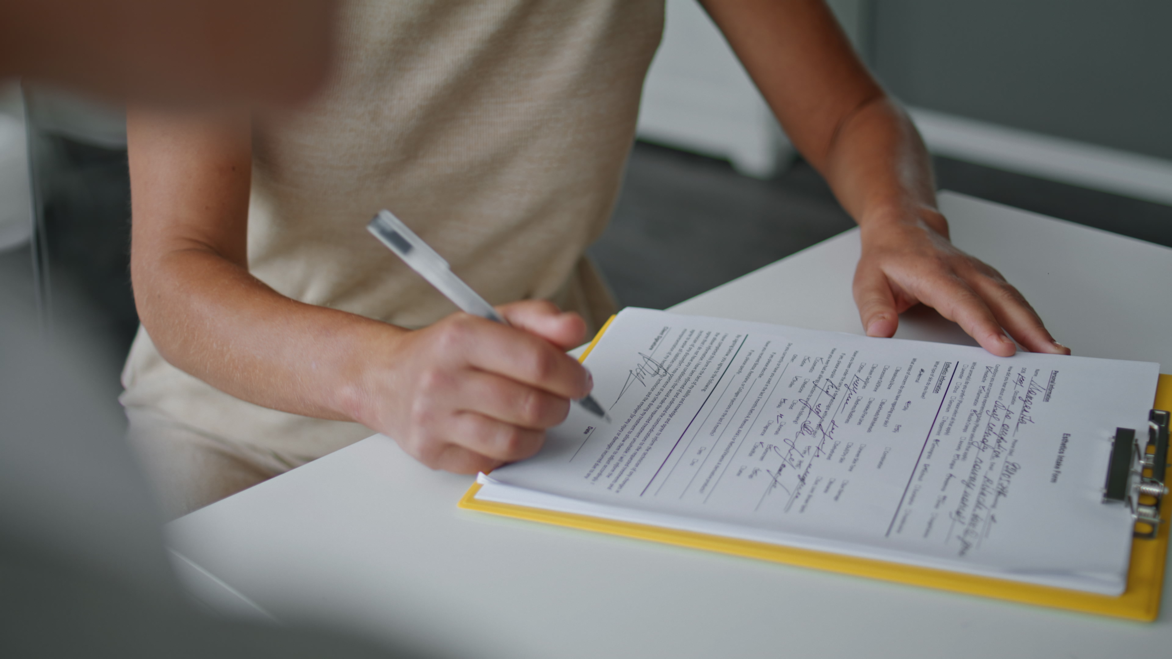 Woman hands signing papers sitting at table close up. Girl writing documents.